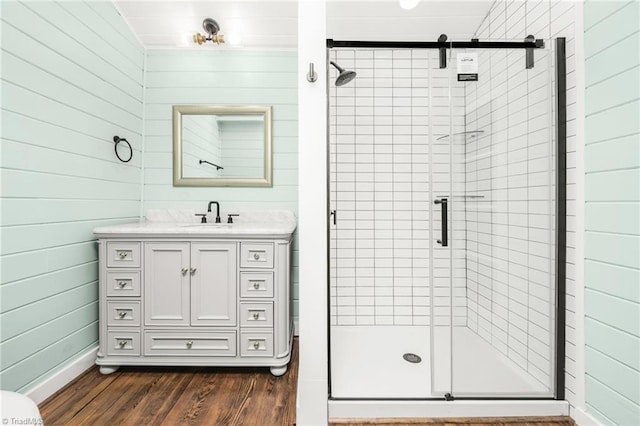 full bath with a stall shower, vanity, and wood finished floors