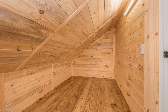 bonus room with wooden ceiling, wood walls, and wood finished floors