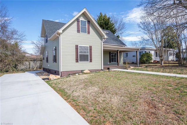 traditional home featuring covered porch, a front lawn, and concrete driveway