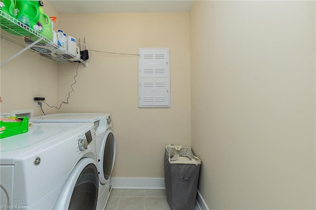 washroom featuring light tile patterned floors, baseboards, separate washer and dryer, and laundry area