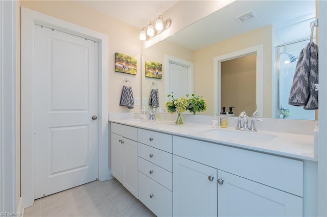 full bath featuring a sink, visible vents, double vanity, and tile patterned floors