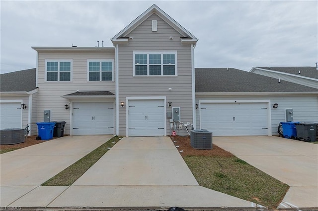 back of house featuring a garage, central AC unit, and concrete driveway