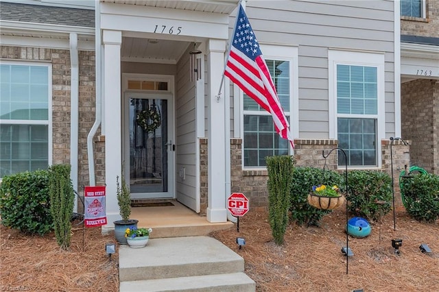 doorway to property featuring brick siding