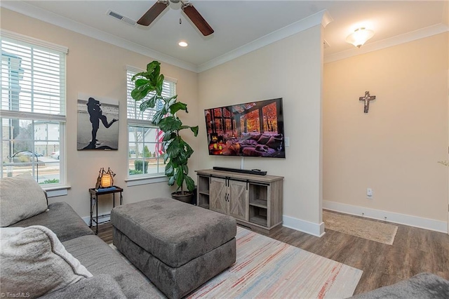 living room with visible vents, crown molding, baseboards, wood finished floors, and a ceiling fan