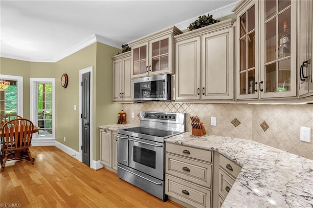 7821 Charles Place Dr, Kernersville, NC 27284 - kitchen with appliances with stainless steel finishes, cream cabinets, light wood-type flooring, decorative backsplash, and ornamental molding