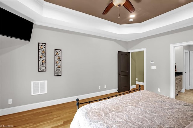 7821 Charles Place Dr, Kernersville, NC 27284 - bedroom featuring a raised ceiling, light wood finished floors, a ceiling fan, and crown molding