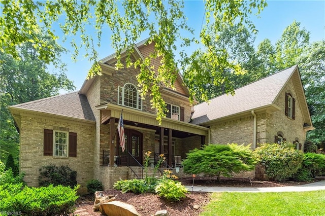 7821 Charles Place Dr, Kernersville, NC 27284 - view of front of house featuring a porch, roof with shingles, stone siding, and brick siding