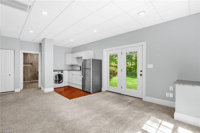 7821 Charles Place Dr, Kernersville, NC 27284 - kitchen with freestanding refrigerator, washer / dryer, carpet flooring, white cabinets, and a drop ceiling