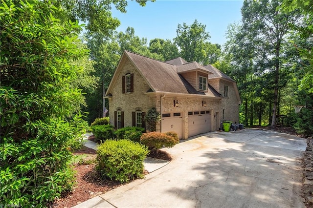 7821 Charles Place Dr, Kernersville, NC 27284 - view of side of home with driveway, a garage, and stone siding