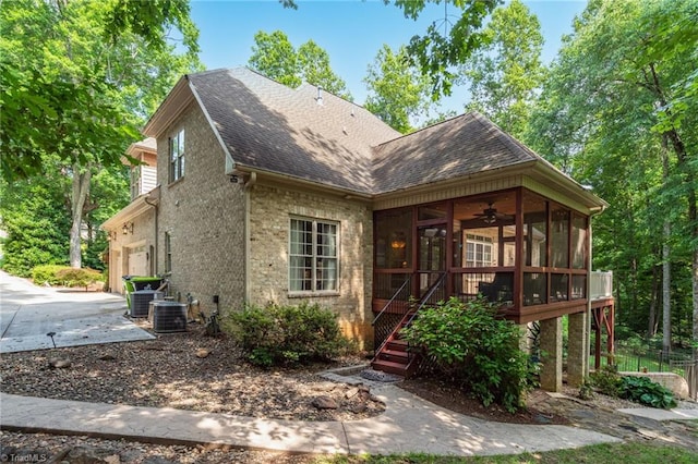 7821 Charles Place Dr, Kernersville, NC 27284 - view of front facade featuring a sunroom, a garage, driveway, roof with shingles, and stairway