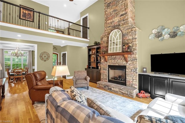 7821 Charles Place Dr, Kernersville, NC 27284 - living area with wood finished floors, a high ceiling, a chandelier, a stone fireplace, and recessed lighting