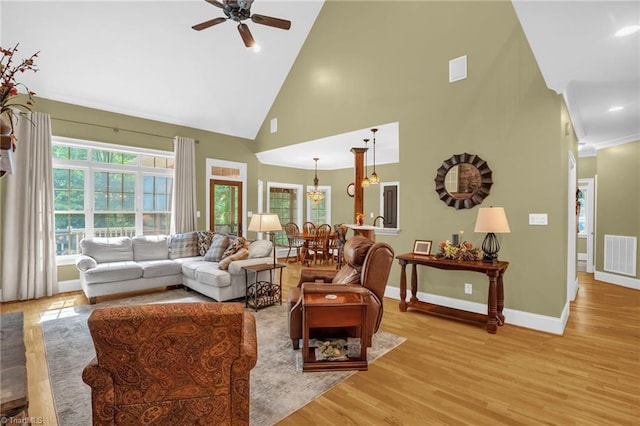 7821 Charles Place Dr, Kernersville, NC 27284 - living room with a ceiling fan, high vaulted ceiling, light wood-style floors, and a chandelier