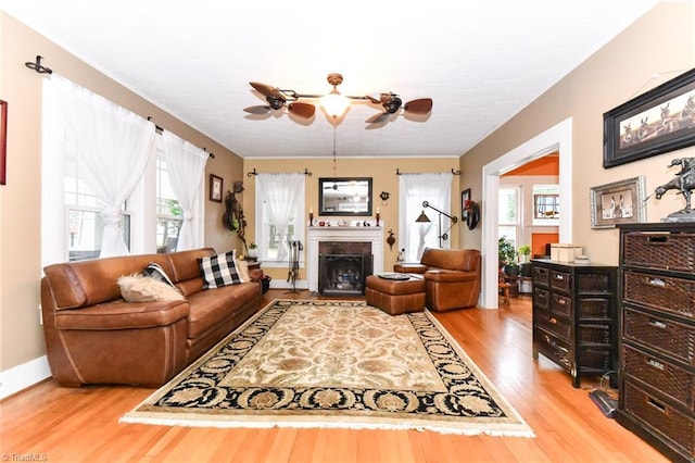 living room featuring wood-type flooring, plenty of natural light, and ceiling fan