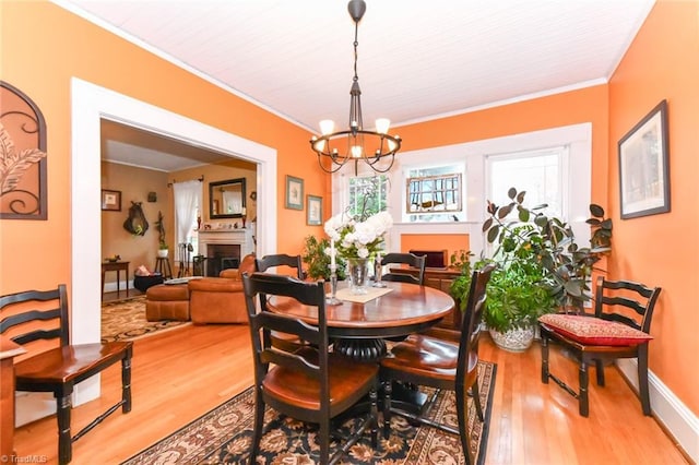 dining room with light hardwood / wood-style floors, crown molding, and a notable chandelier