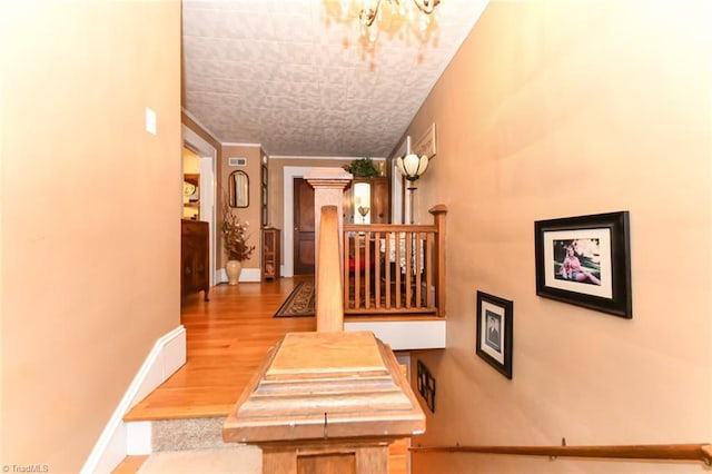 hall with wood-type flooring and ornamental molding