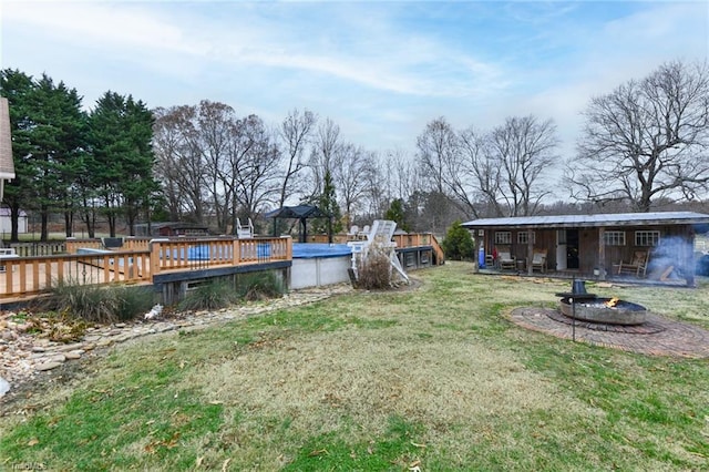 view of yard with a covered pool and an outdoor fire pit