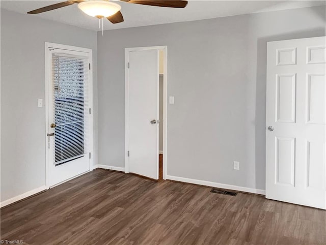 spare room featuring ceiling fan and dark hardwood / wood-style flooring