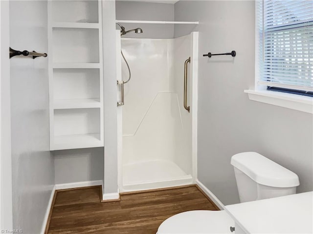 bathroom with a shower, hardwood / wood-style floors, and toilet