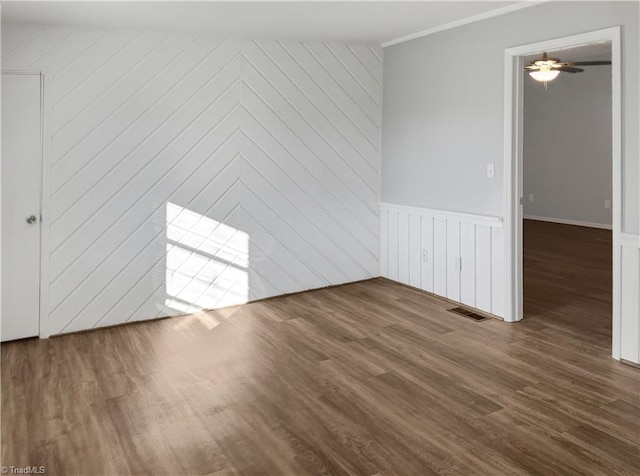 spare room featuring ceiling fan and dark wood-type flooring