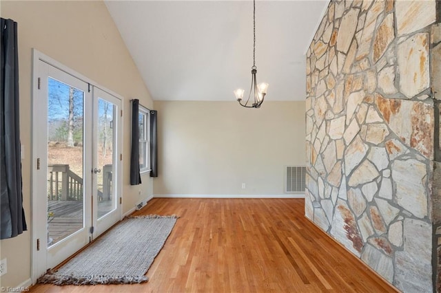 dining room with high vaulted ceiling, a notable chandelier, wood finished floors, visible vents, and baseboards