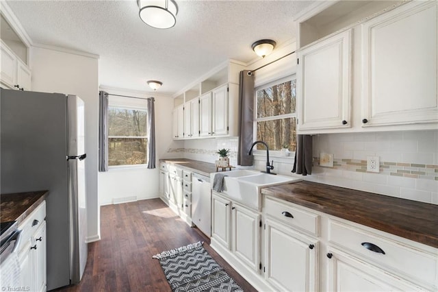 kitchen with appliances with stainless steel finishes, dark wood-type flooring, a sink, and white cabinetry