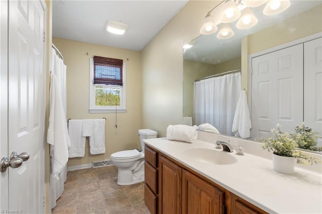 bathroom with baseboards, visible vents, vanity, and toilet