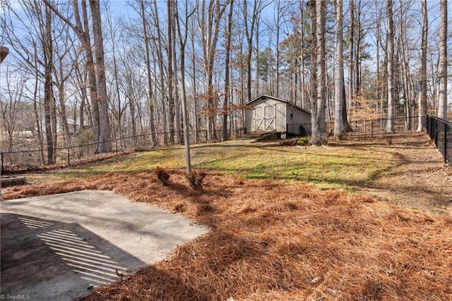 view of yard featuring a barn, fence, an outdoor structure, and a patio