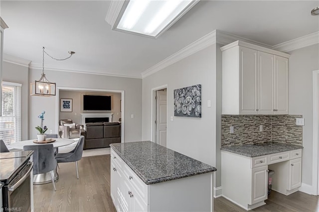 kitchen featuring dark stone counters, backsplash, wood finished floors, and white cabinetry