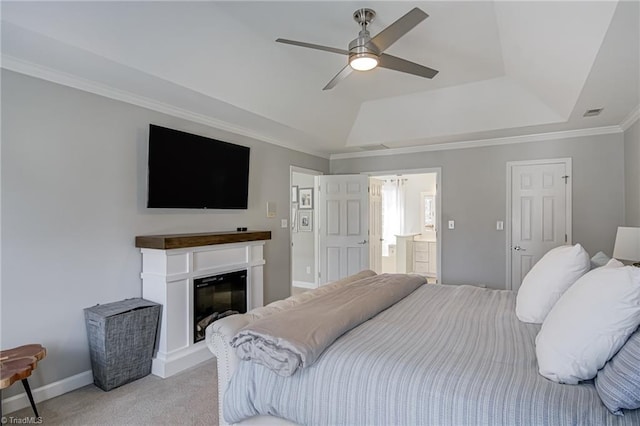 bedroom featuring baseboards, a glass covered fireplace, crown molding, light colored carpet, and a raised ceiling