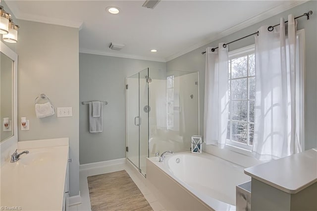 bathroom featuring vanity, a garden tub, a stall shower, and ornamental molding