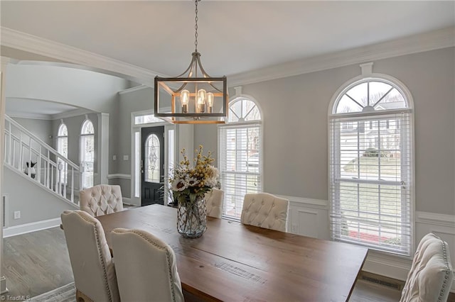 dining room featuring stairs, crown molding, wood finished floors, and visible vents