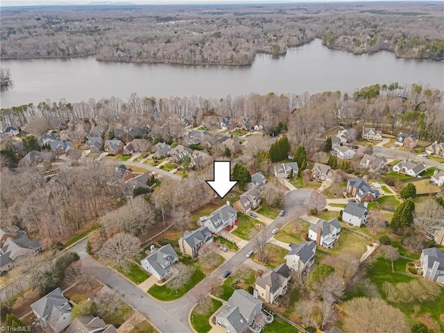 aerial view featuring a wooded view, a residential view, and a water view