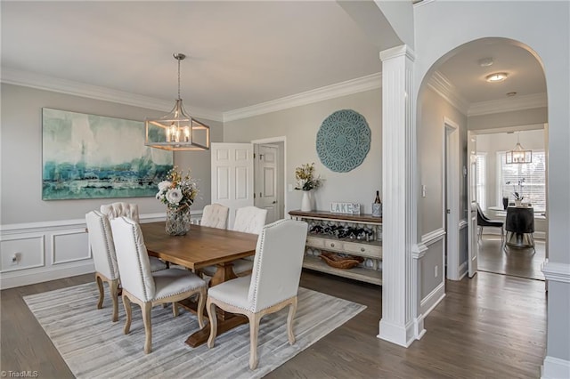 dining space featuring arched walkways, a notable chandelier, and wood finished floors