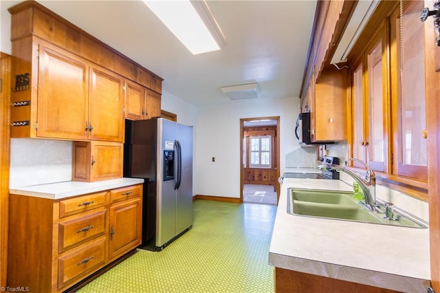 kitchen with sink, stove, and stainless steel refrigerator with ice dispenser