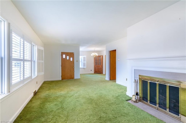 unfurnished living room featuring carpet flooring and a chandelier