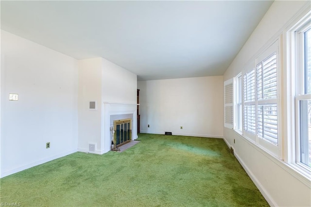 unfurnished living room featuring carpet flooring and plenty of natural light