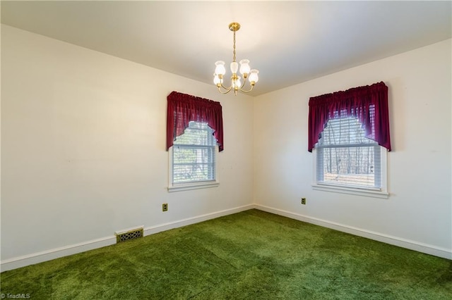 carpeted empty room featuring a notable chandelier