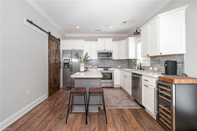 7634 Grapevine Rd, Lewisville, NC 27023 - kitchen with a kitchen island, white cabinets, appliances with stainless steel finishes, and dark wood finished floors