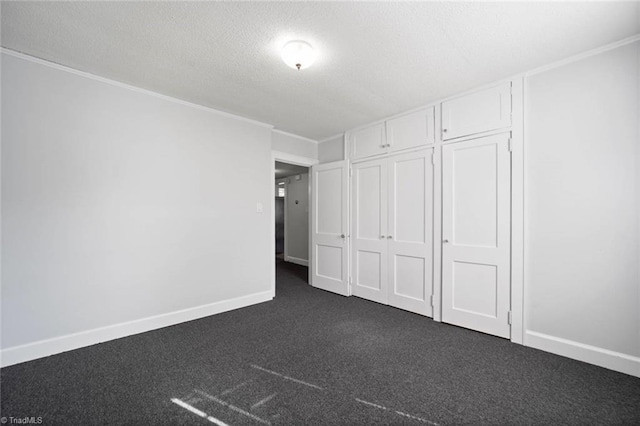 3231 Arlington Dr, Winston-Salem, NC 27103 - unfurnished bedroom with dark colored carpet, a textured ceiling, crown molding, and a closet