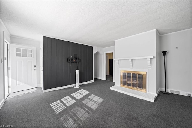 3231 Arlington Dr, Winston-Salem, NC 27103 - unfurnished living room featuring a textured ceiling, crown molding, a glass covered fireplace, and carpet floors