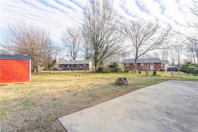 view of yard featuring a shed and a patio area