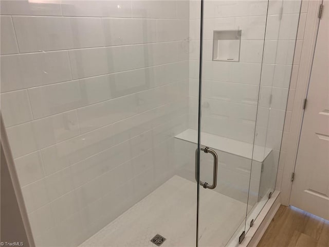 bathroom featuring hardwood / wood-style flooring and a shower with door