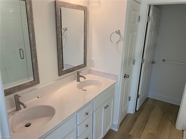 bathroom with a shower with door, vanity, and wood-type flooring