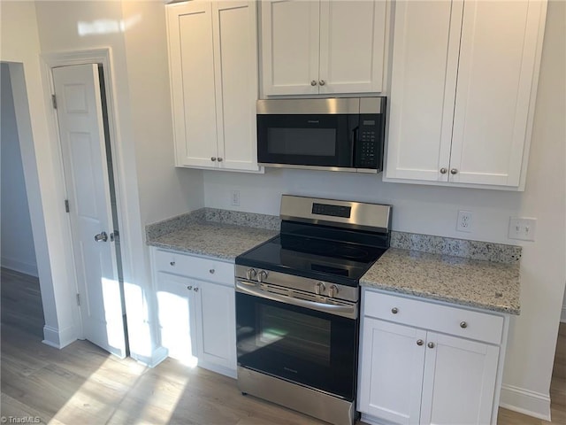 kitchen featuring white cabinetry, light hardwood / wood-style floors, and appliances with stainless steel finishes