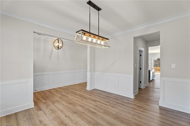 271 Redland Rd, Advance, NC 27006 - unfurnished dining area featuring a chandelier, a wainscoted wall, wood finished floors, ornamental molding, and a decorative wall