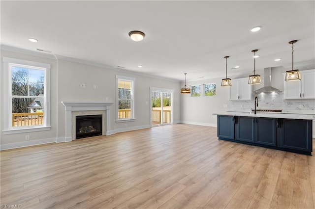 271 Redland Rd, Advance, NC 27006 - kitchen featuring wall chimney range hood, light countertops, white cabinetry, light wood finished floors, and recessed lighting