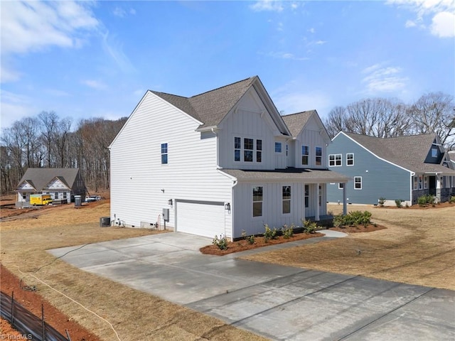 271 Redland Rd, Advance, NC 27006 - view of front of property featuring board and batten siding, an attached garage, driveway, a shingled roof, and covered porch