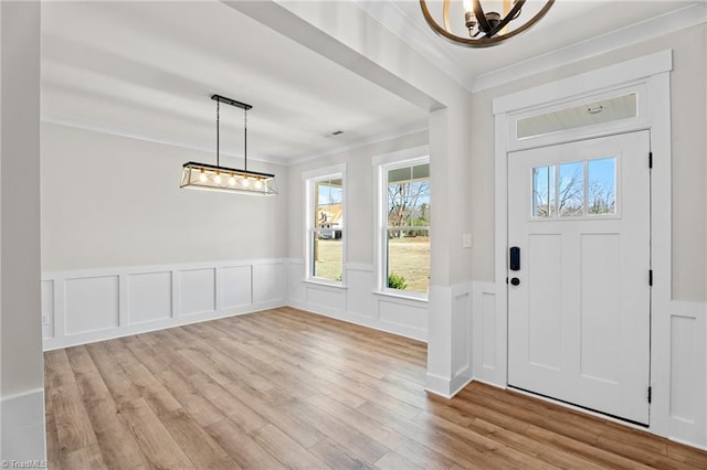 271 Redland Rd, Advance, NC 27006 - entryway featuring a chandelier, light wood-style floors, crown molding, wainscoting, and a decorative wall