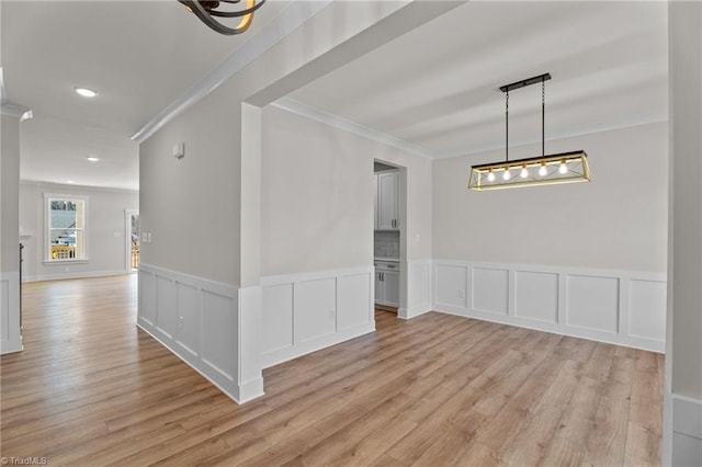 271 Redland Rd, Advance, NC 27006 - empty room with crown molding, light wood-style flooring, wainscoting, recessed lighting, and a decorative wall