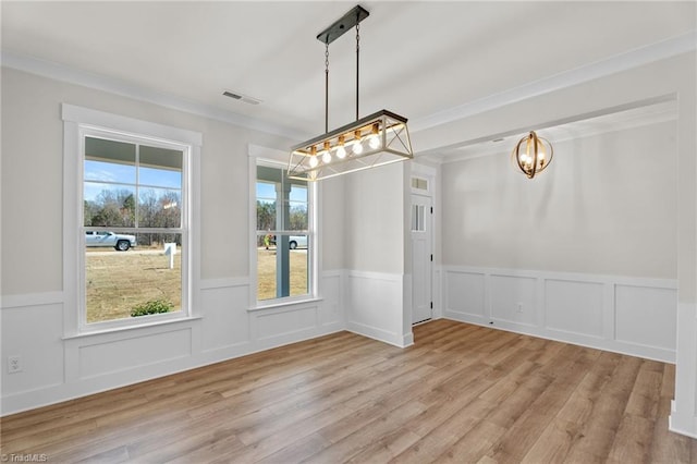 271 Redland Rd, Advance, NC 27006 - unfurnished dining area with a chandelier, wood finished floors, wainscoting, crown molding, and a decorative wall